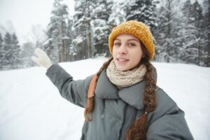 Young female travel blogger giving tour in winter forest